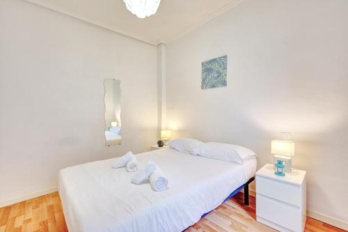 a white bedroom with a bed with towels on it at Santo Tomás I in Haro