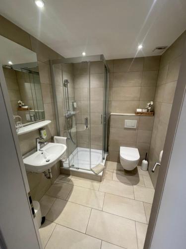 a bathroom with a shower and a toilet and a sink at Gasthaus Sonnen in Trierweiler