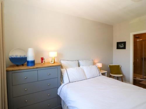 a bedroom with a bed and a dresser with a lamp at 28 Long Quay in Cork