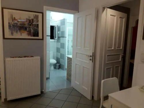 a bathroom with a toilet and a white door at Διαμέρισμα με πανοραμική θέα στη θάλασσα & ιδιωτική παραλία in Koumárion
