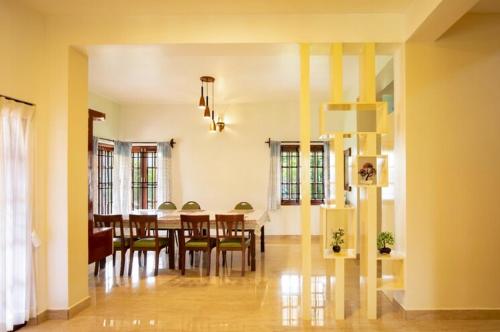 a dining room with a table and chairs in a room at Habba Kadal Kashmiri Heritage Hotel & Hub in Coonoor