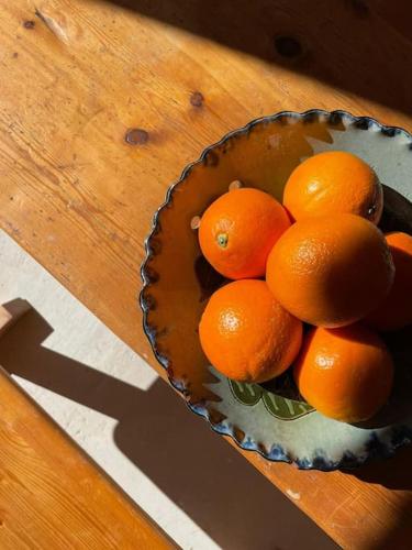 a bowl of oranges sitting on a wooden table at Habitación L'Elefant en Casa Camí de les Aigües Monistrol de Montserrat in Monistrol