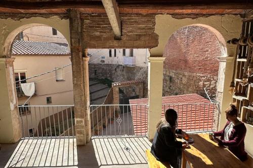 two women sitting on a table in a building at Habitación L'Elefant en Casa Camí de les Aigües Monistrol de Montserrat in Monistrol