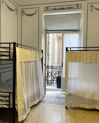 a bedroom with two bunk beds and a door to a balcony at The Cathedral Hostel in Murcia