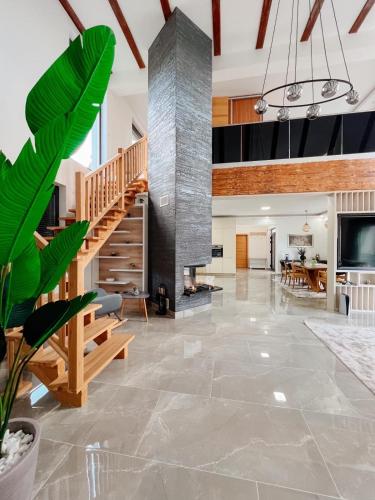a living room with a staircase and a dining room at Villa Bosanska Zvijezda in Vlasic