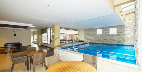 a swimming pool in a room with a table and chairs at Ecuabook torre sol 32 mall del Sol in Guayaquil