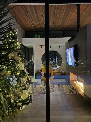 a living room with a christmas tree and a television at Luxury Villa Spectacular Views Sauna Jacuzzi BBQ in Dosquebradas