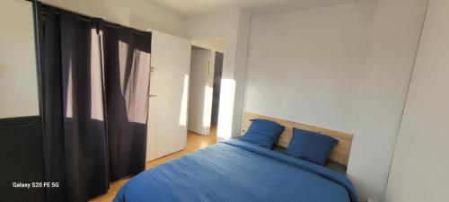 a bedroom with a blue bed with blue pillows at maison cosy in Quimper