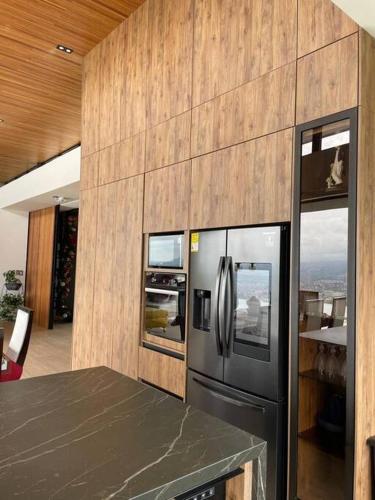 a kitchen with a stainless steel refrigerator and a counter at Luxury Villa Spectacular Views Sauna Jacuzzi BBQ in Dosquebradas