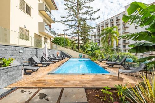 an image of a swimming pool with chaise lounge chairs at Casa das Raposinhas I in Funchal