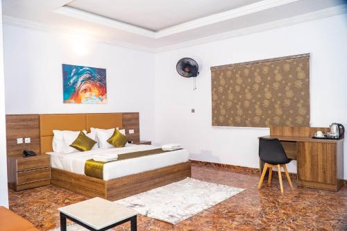 a hotel room with a bed and a desk at Ringruby Hotel, Sangotedo in Sangotedo