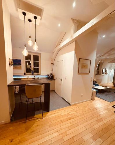 - une cuisine avec un comptoir et une table dans une pièce dans l'établissement So Guest- Pépite de charme proche cathédrale, climatisation Parking, à Reims
