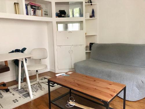 un salon avec un lit et une table dans l'établissement Joli studio Boulogne proche Paris, à Boulogne-Billancourt