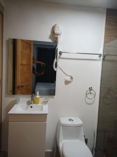 a bathroom with a toilet and a sink and a mirror at The most comfortable apartment in Boca Chica in Boca Chica