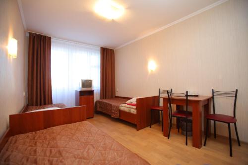 a hotel room with a bedroom with a table and a bed at Ostrovok Hotel in Saint Petersburg