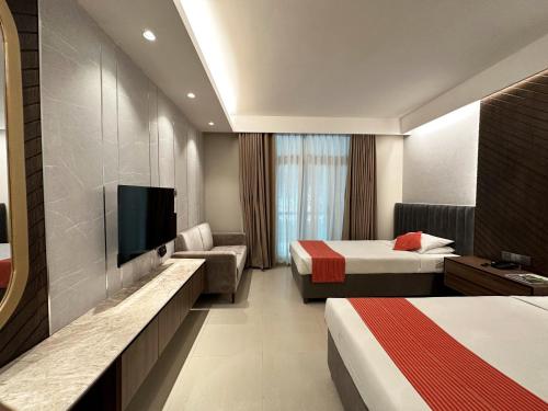 a hotel room with two beds and a flat screen tv at Foy's Lake Resort in Chittagong