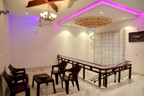 a room with a table and chairs and purple lighting at Patiala Bliss Villa in Patiāla