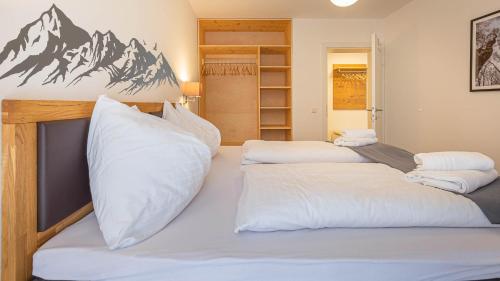 a bedroom with two beds with white pillows at Grimming Lodge by keyone in Tauplitz