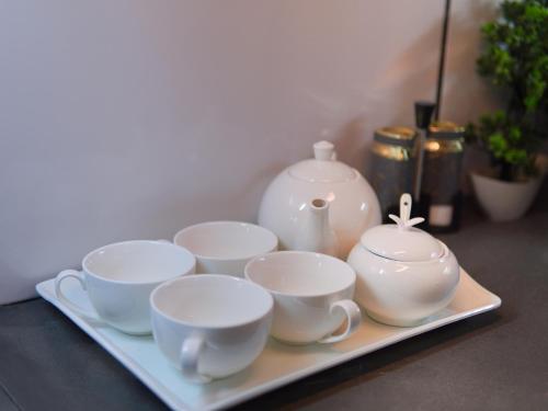 a tray with four cups and a tea set on it at Fior Residence 1BHK Apt in Rawalpindi