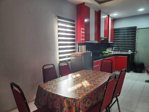 a kitchen with a table and chairs and red cabinets at D'Haja 56 KLIA SEPANG with 3 AIRCONDS & FREE Wi-Fi in Banting