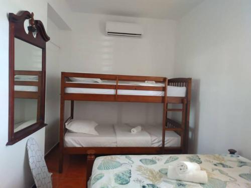a small room with a bunk bed and a mirror at Cabanas Playa Santa Apto D Piscinas Solar Energy in Guanica