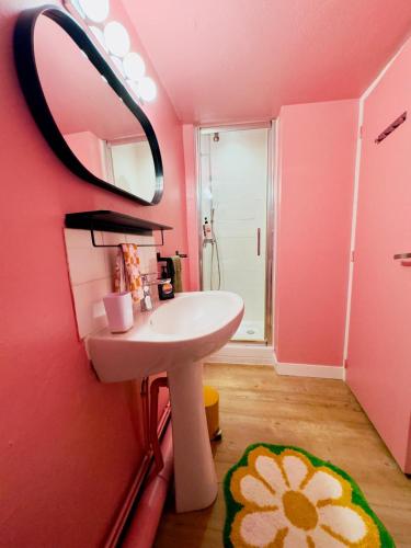 une salle de bain rose avec un lavabo et un miroir dans l'établissement NEW! BAGAJ Studio 70's hyper centre, à La Rochelle