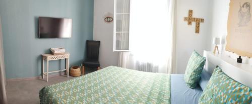 une chambre avec un lit et une télévision dans l'établissement Bel F2 près de la plage, à Ajaccio