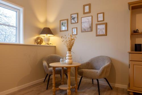 a room with two chairs and a table and a window at B&B Iets Zeeuws in Kats