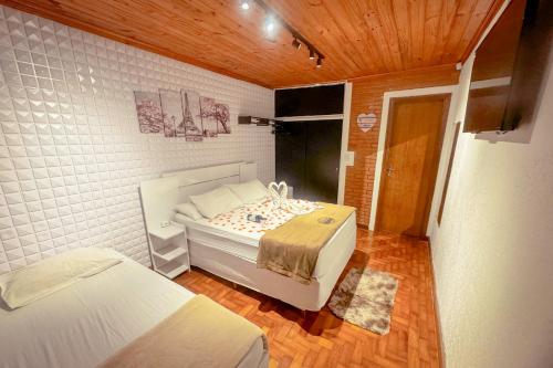 a bedroom with two beds in a room at VELINN Pousada Casa de Campos Capivari House in Campos do Jordão