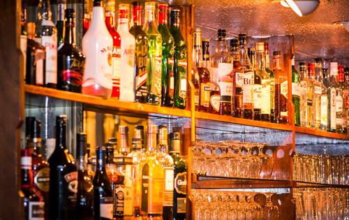 a bar filled with lots of bottles and glasses at Haddon House Hotel in Bridport