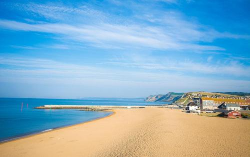 a view of a beach with the ocean and buildings at Haddon House Hotel in Bridport