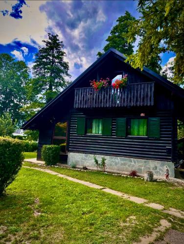 a house with a balcony with flowers on it at Apartma Dobnik in Mozirje