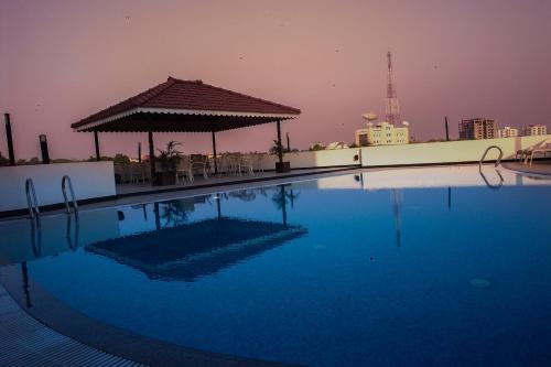 a swimming pool with a gazebo on top of a building at Park Connect in Cochin