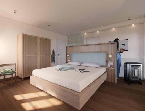 a woman standing in a bedroom with a large bed at Gartenvilla in Marktheidenfeld