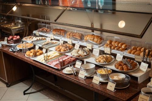 a buffet line with different types of pastries and bread at Hotel Villa Michelon in Bento Gonçalves