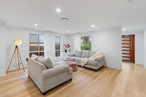 a living room with two chairs and a couch at Stunning 5BR Big Modern Home with Parking Malls and Parks in Brisbane