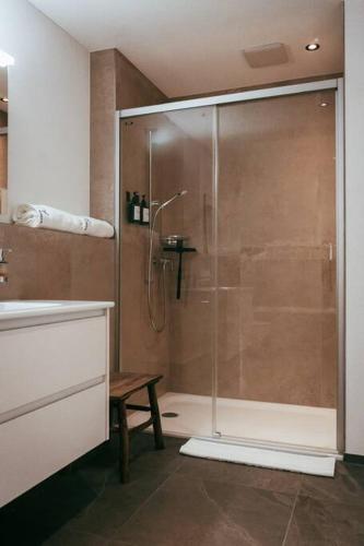 a shower with a glass door in a bathroom at Hidden Retreats The Blausee in Frutigen