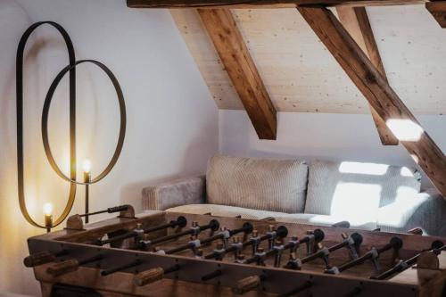 a living room with a foosball table in front of a couch at Hidden Retreats The Blausee in Frutigen