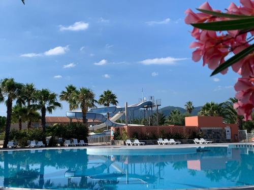 a swimming pool with a water park in the background at Camping Del Mar B10, Mobile Home Excellence, 3 chambres, 6 personnes, bord de mer in Argelès-sur-Mer