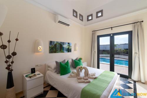 sypialnia z łóżkiem z zielonymi i białymi poduszkami w obiekcie Casa Bonita - LH144 By Villas Now Ltd w mieście Playa Blanca
