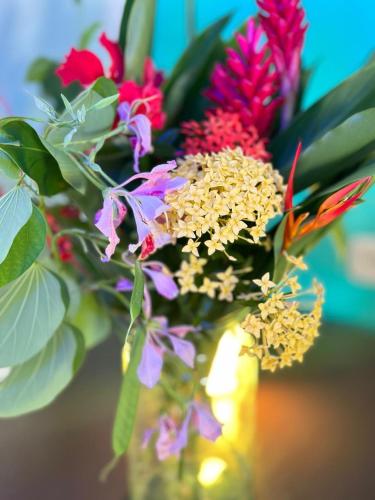 a vase filled with colorful flowers on a table at Hotel Maritza in Puerto Viejo