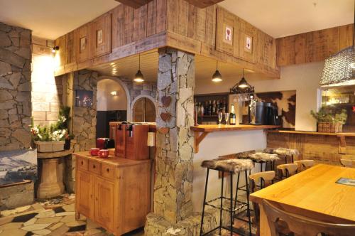 La cuisine est équipée d'un réfrigérateur et d'un bar avec tabourets. dans l'établissement Le Passe Montagne, à Saint-Chaffrey