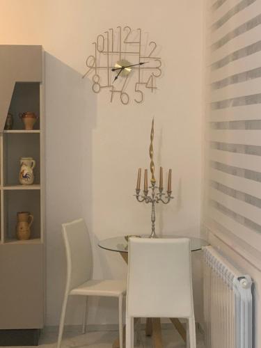 a dining room with a table and chairs and a clock at B&B Passione Salento in Surbo