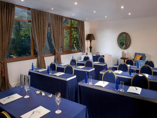 a conference room with blue tables and chairs at Xenia Palace Portaria in Portariá
