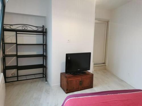 un salon avec une télévision sur une table en bois dans l'établissement Studio RDC, à Loriol-sur-Drôme