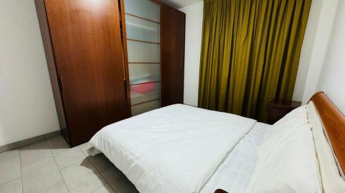 a bedroom with a white bed and a wooden door at Matis Appartamenti in Camisano