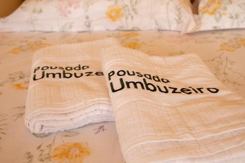 two towels are sitting on a bed at Pousada Umbuzeiro in Piranhas