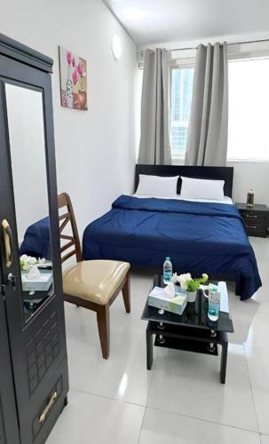 a bedroom with a blue bed and a mirror at Elegant Stay Abu Dhabi City in Abu Dhabi