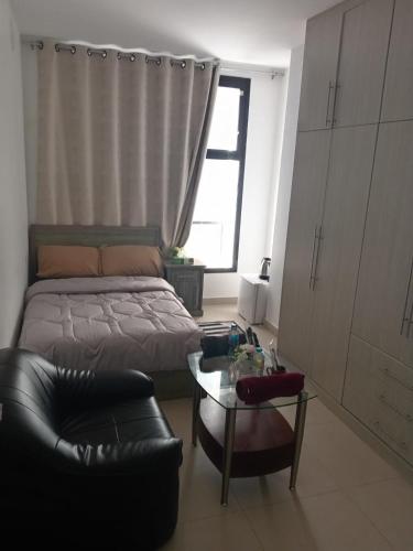 a bedroom with a bed and a couch and a table at Elegant Stay Abu Dhabi City in Abu Dhabi