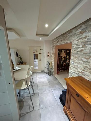 - un salon avec un mur en pierre, une table et des chaises dans l'établissement Charmant, appartement, parking gratuit, à Colmar